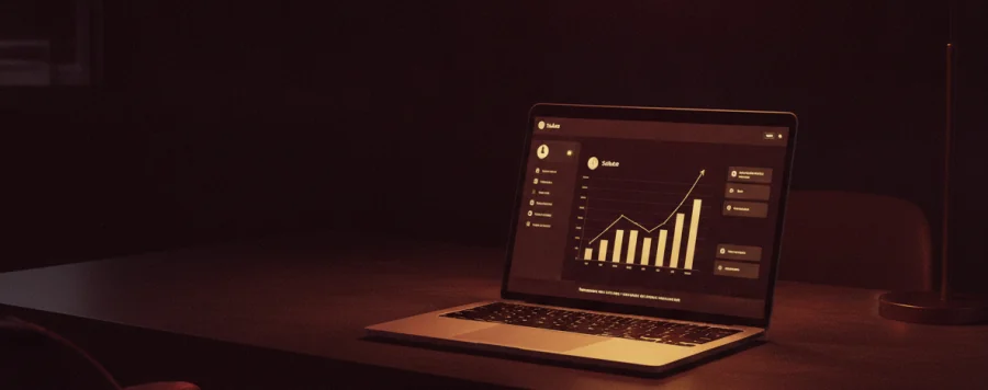 Notebook sobre a mesa exibindo um painel de vendas com gráfico em ascensão.